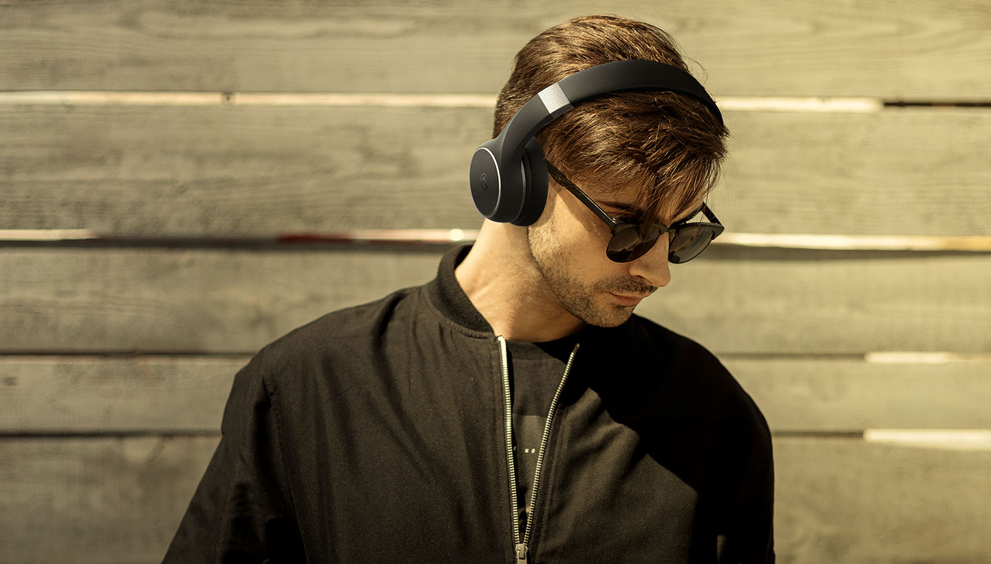 Model stands enjoying the latest MOTO XT 220 Headphones - Content image